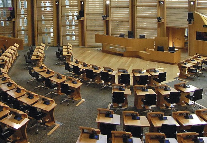 Salle de conférence avec de nombreux bureaux, dominée par des meubles en bois et des terrasses en bois.
