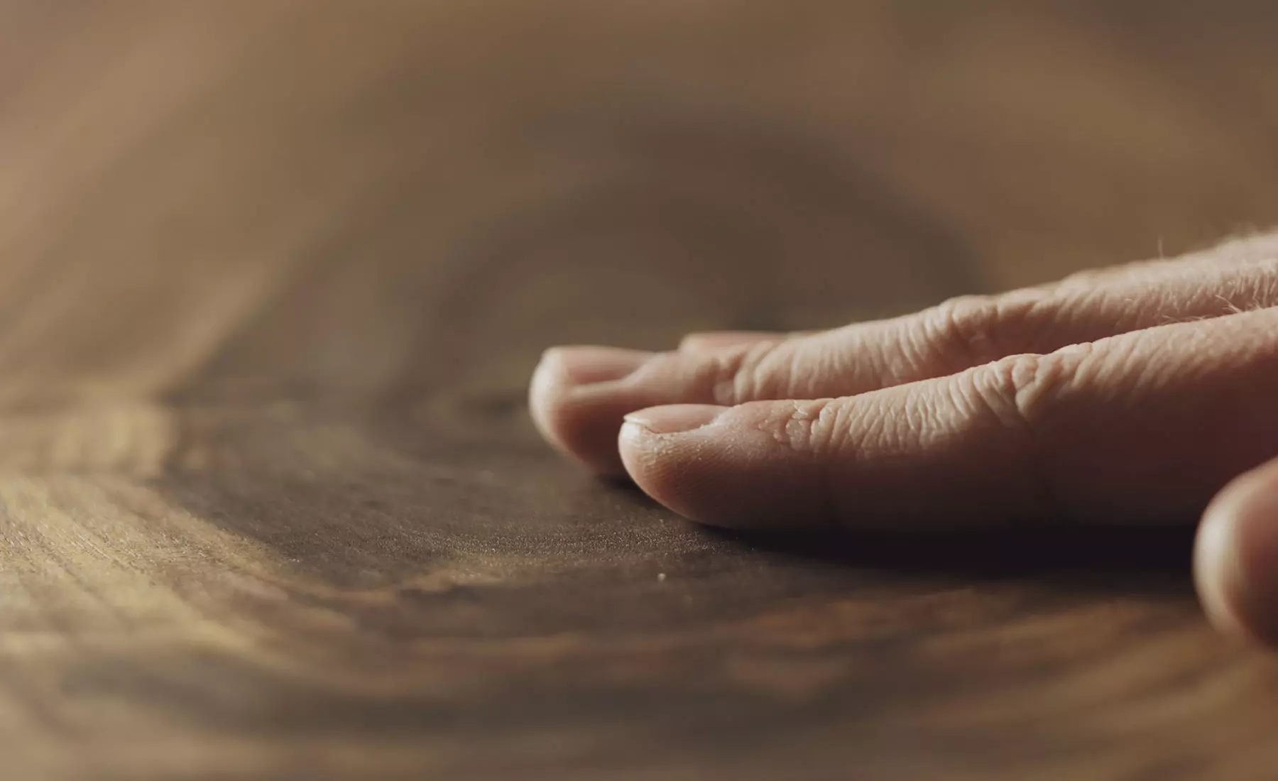 A hand caresses a hardwood board