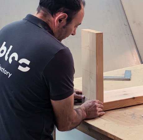 A carpenter carefully positions a piece of wood